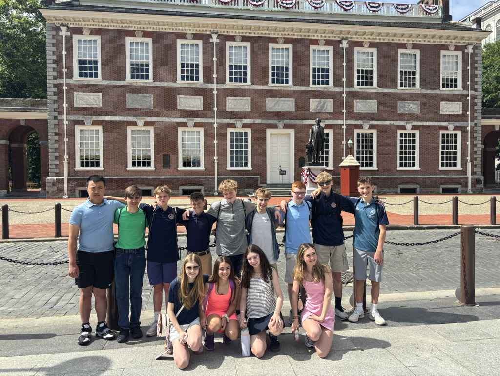 Photos from the 8th grade class trip featuring the whole class in front of Philadelphia landmarks