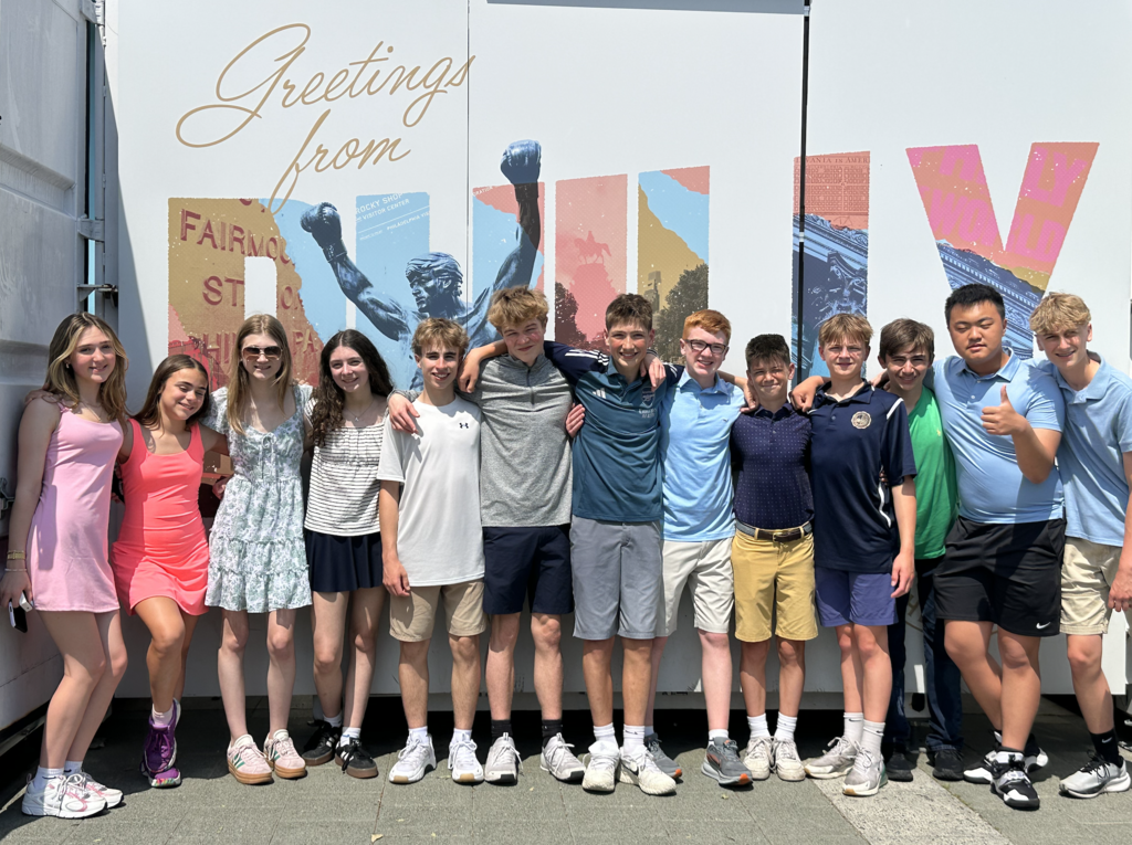 Photos from the 8th grade class trip featuring the whole class in front of Philadelphia landmarks