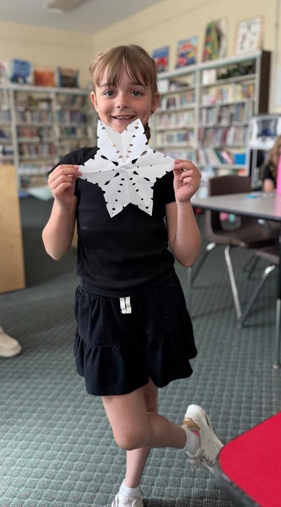 girl with paper showflake she made
