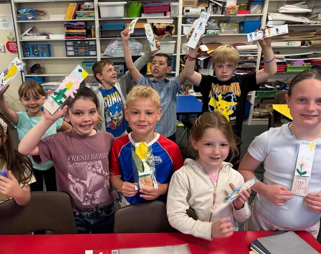 students holding bookmarks they made