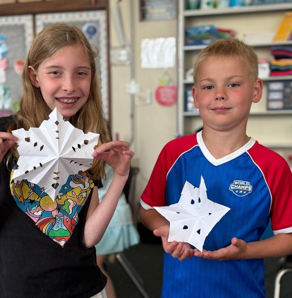 students with paper snowflakes they made
