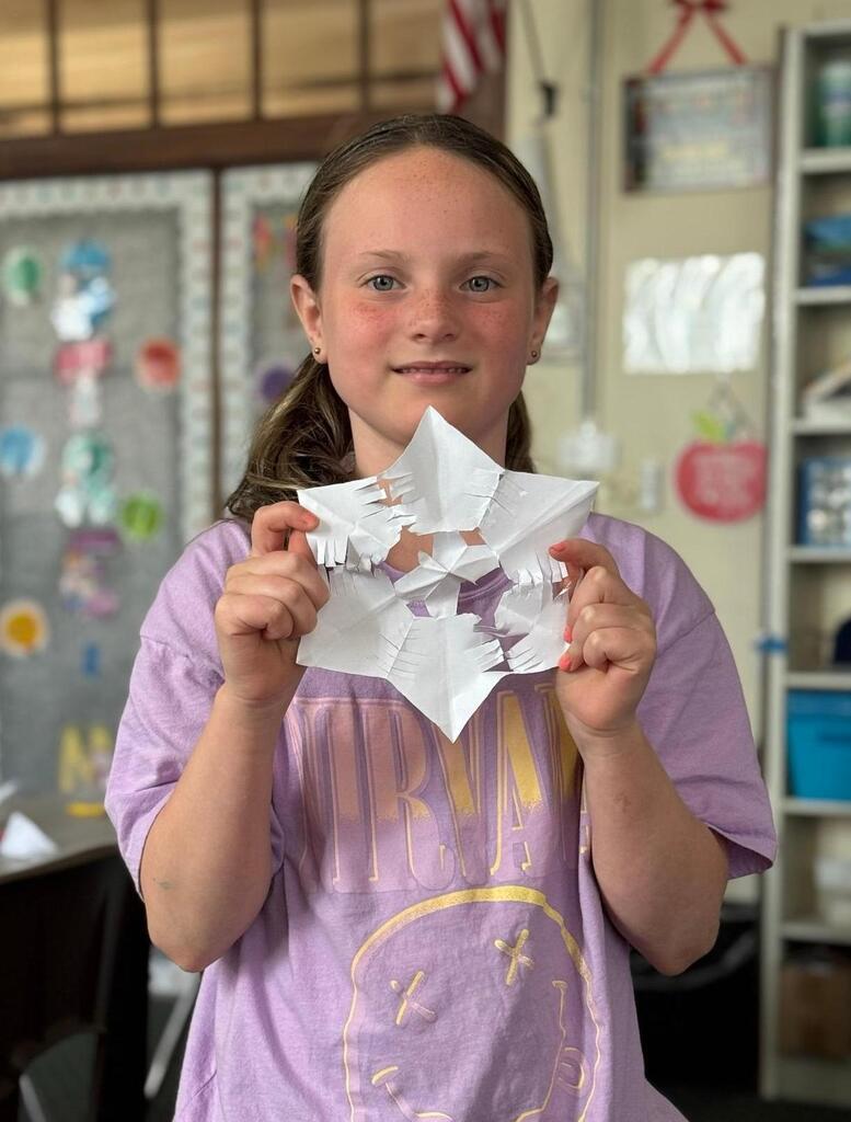 girl with paper showflake she made