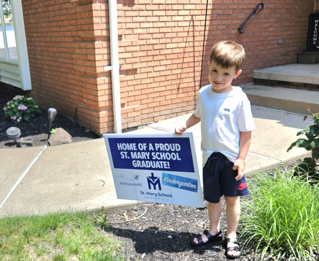 Graduate with lawn sign celebrating their graduation