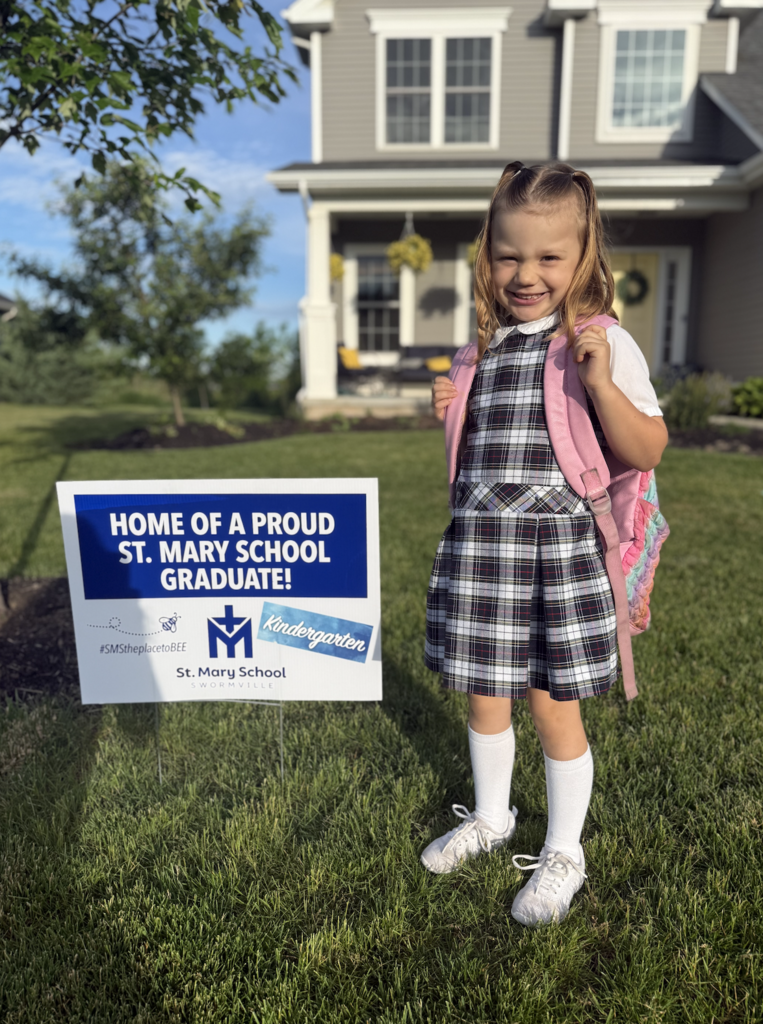 Graduate with lawn sign celebrating their graduation