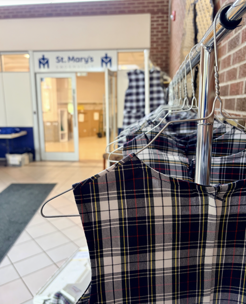 uniform jumpers hanging on a rack in school foyer