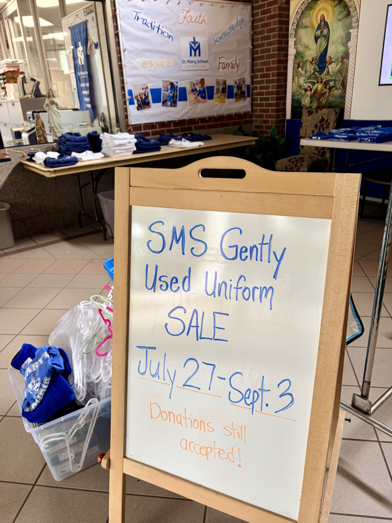 easel board with handwriten text in school foyer denoting dates of uniform sale
