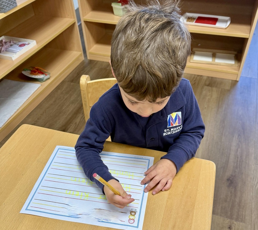 student practicing writing his name