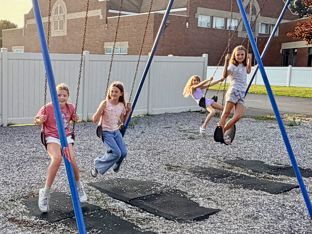 Girls smiling while playing on swings