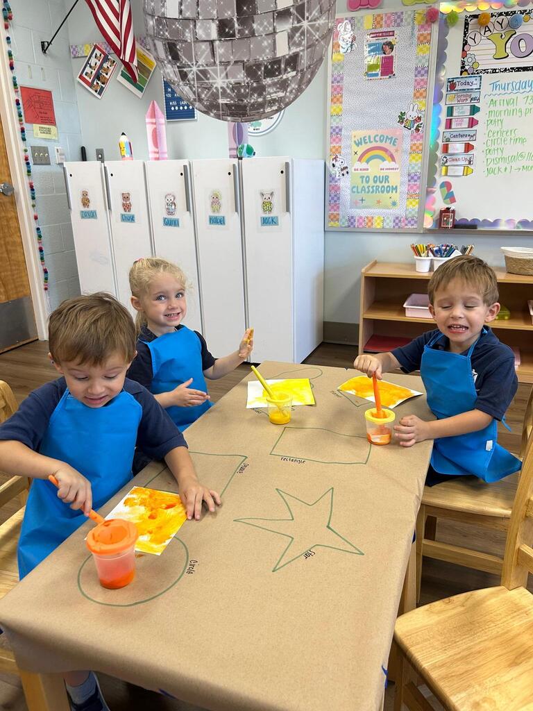 prek students paint with smocks on