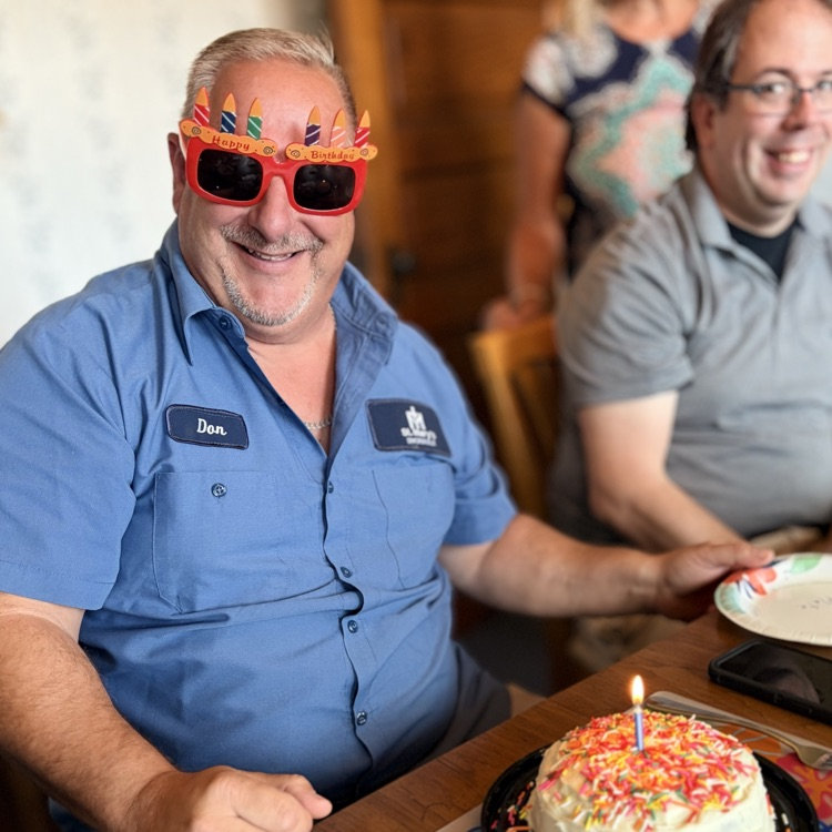 man with sunglasses in front of a birthday cake