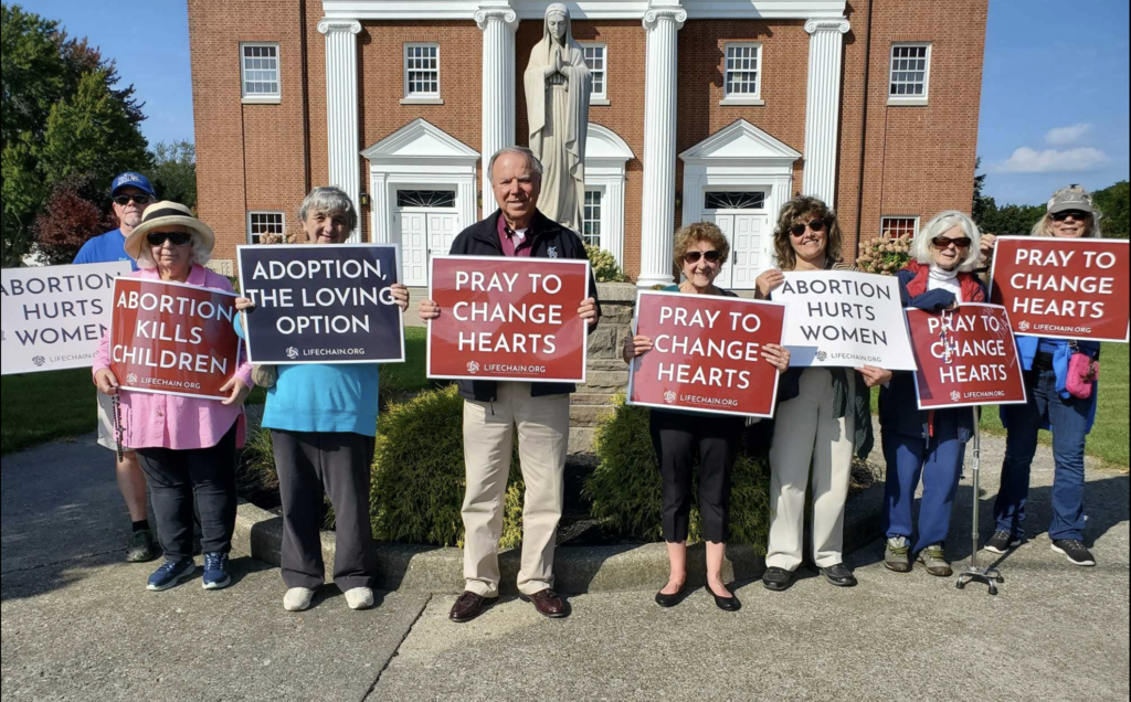 people holding signs outside a church