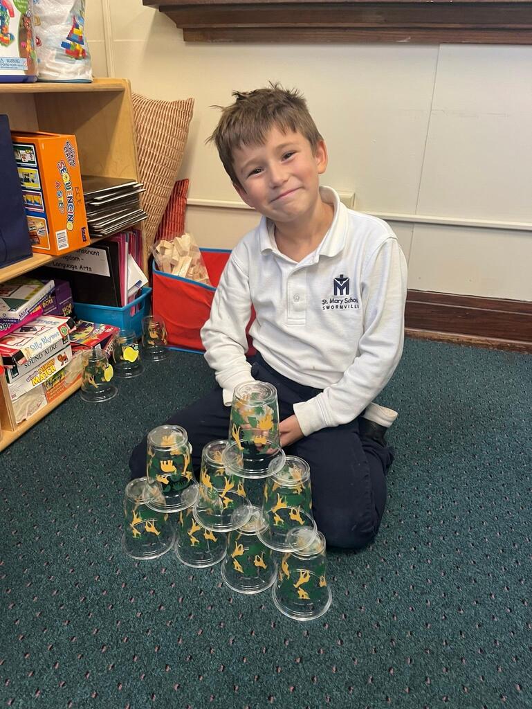 student playing addition cup stacking game