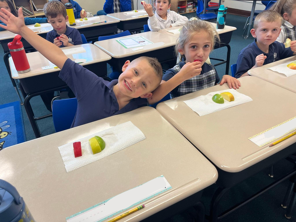 students at their desks eating apples
