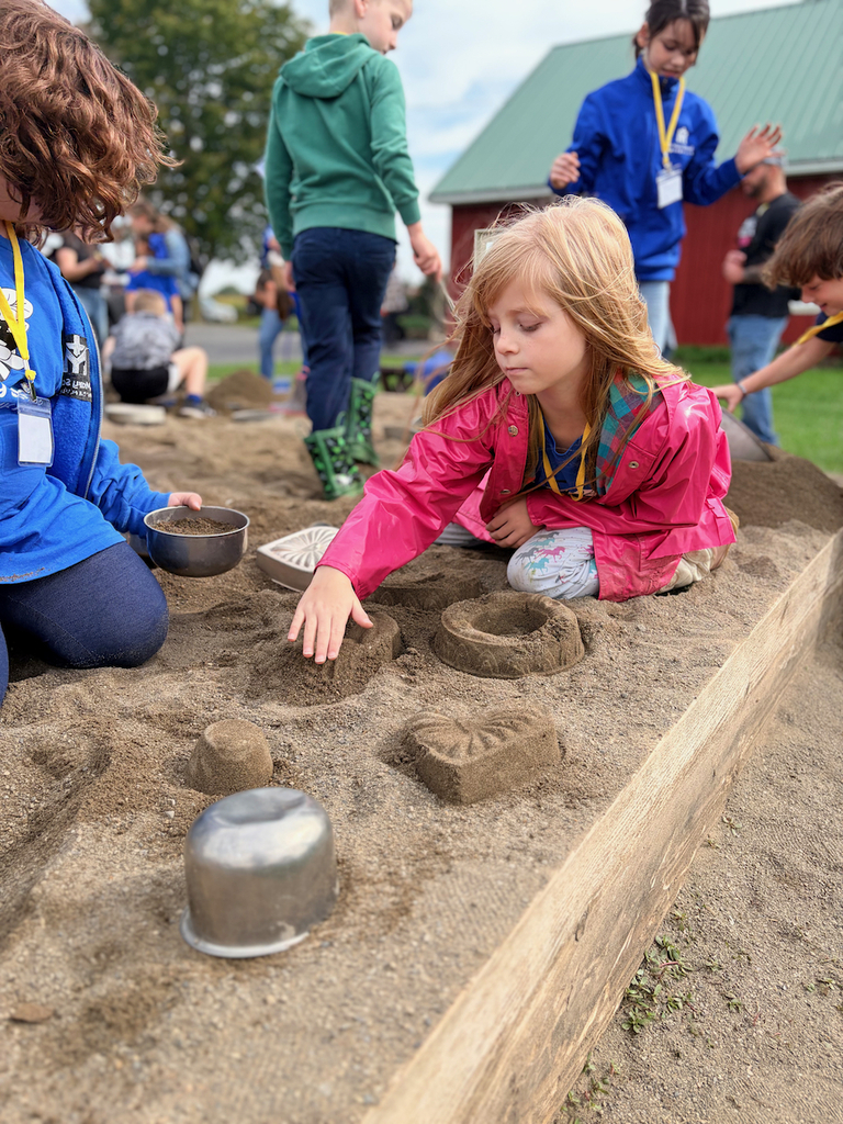 girl playing in sand pit