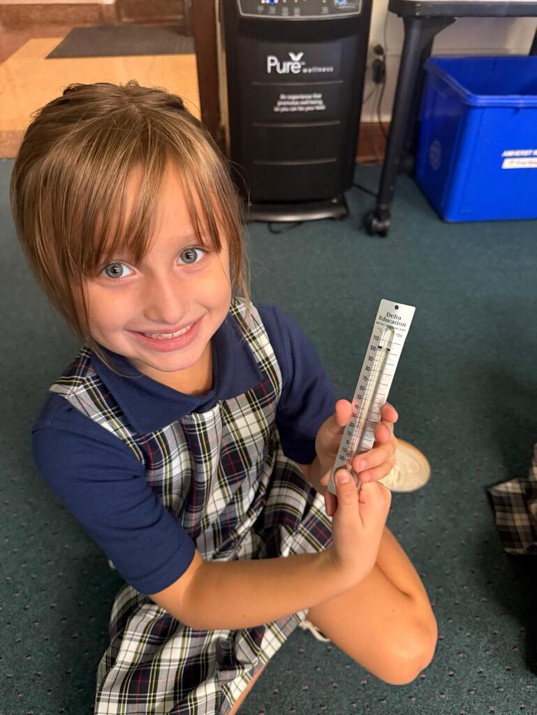 student in grade 2 observing temperature with a thermometer