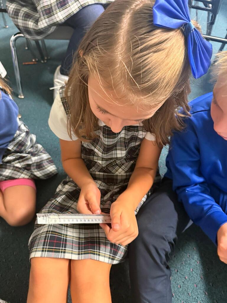 student in grade 2 observing temperature with a thermometer