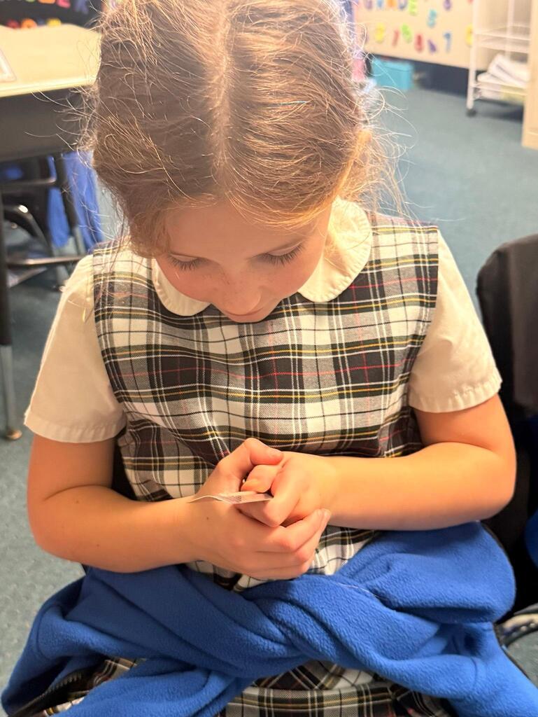 student in grade 2 observing temperature with a thermometer