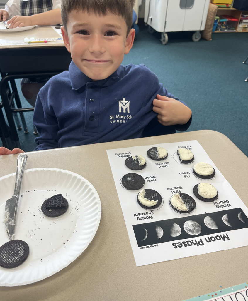 student with moon phases work sheet at desk and oreo cookies