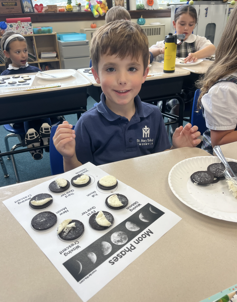 student with moon phases work sheet at desk and oreo cookies