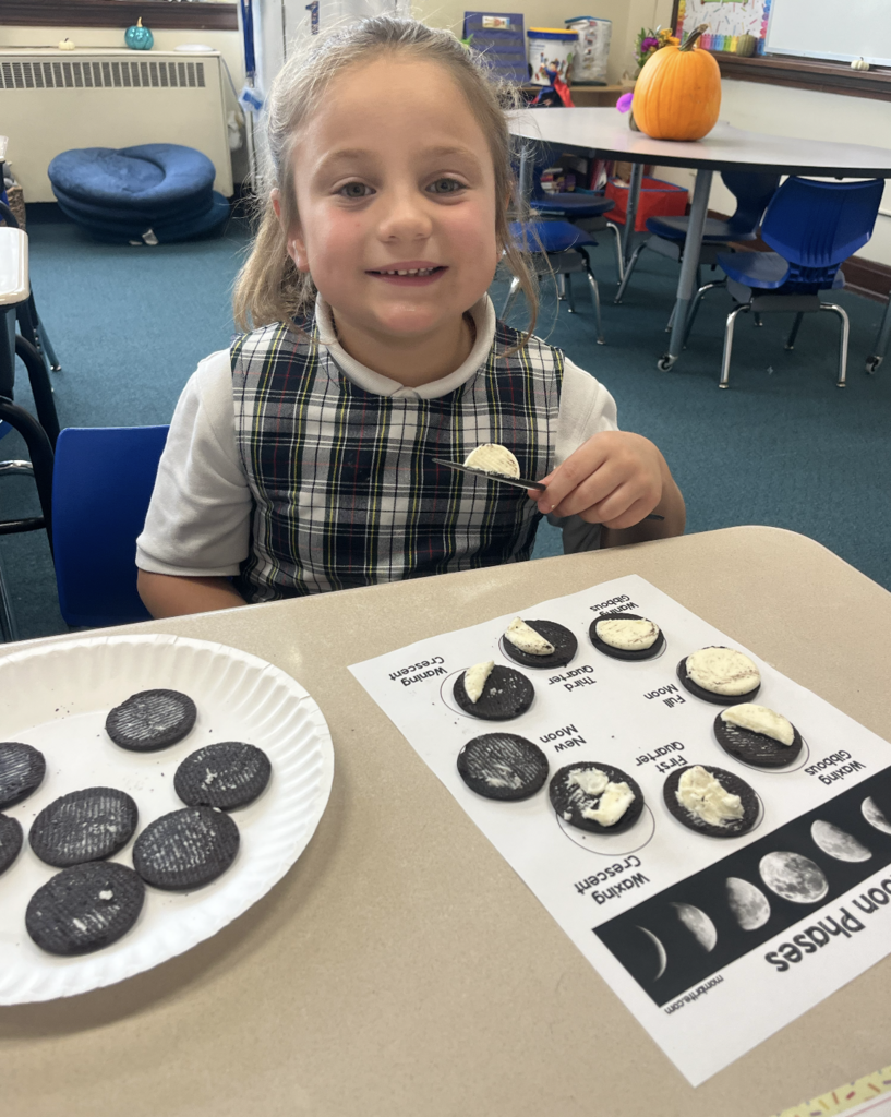 student with moon phases work sheet at desk and oreo cookies