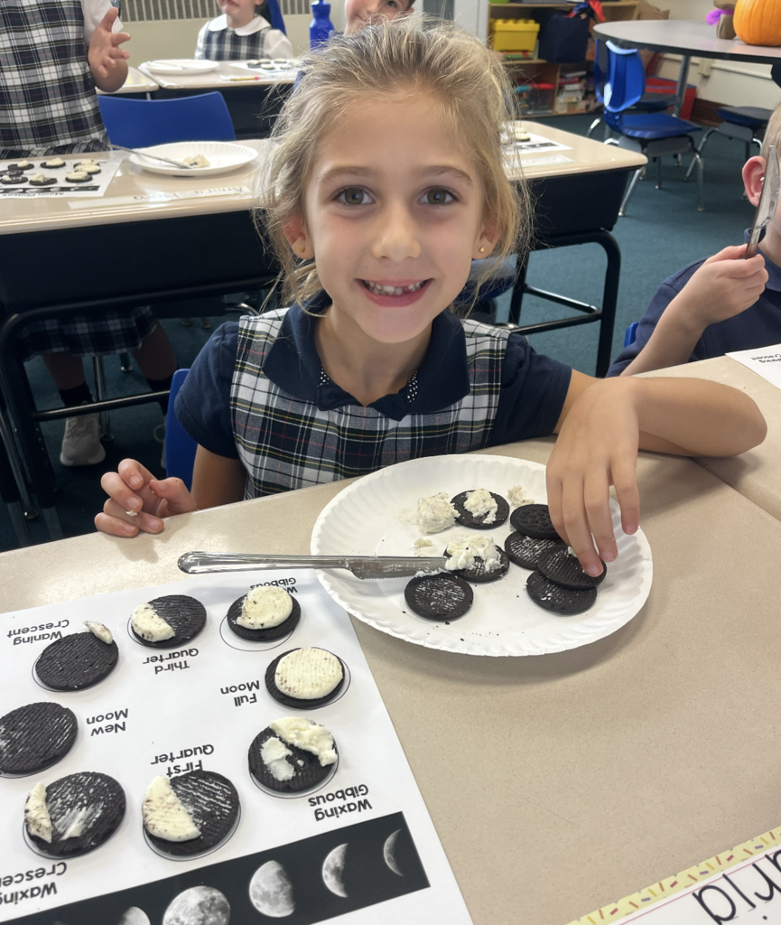 student with moon phases work sheet at desk and oreo cookies