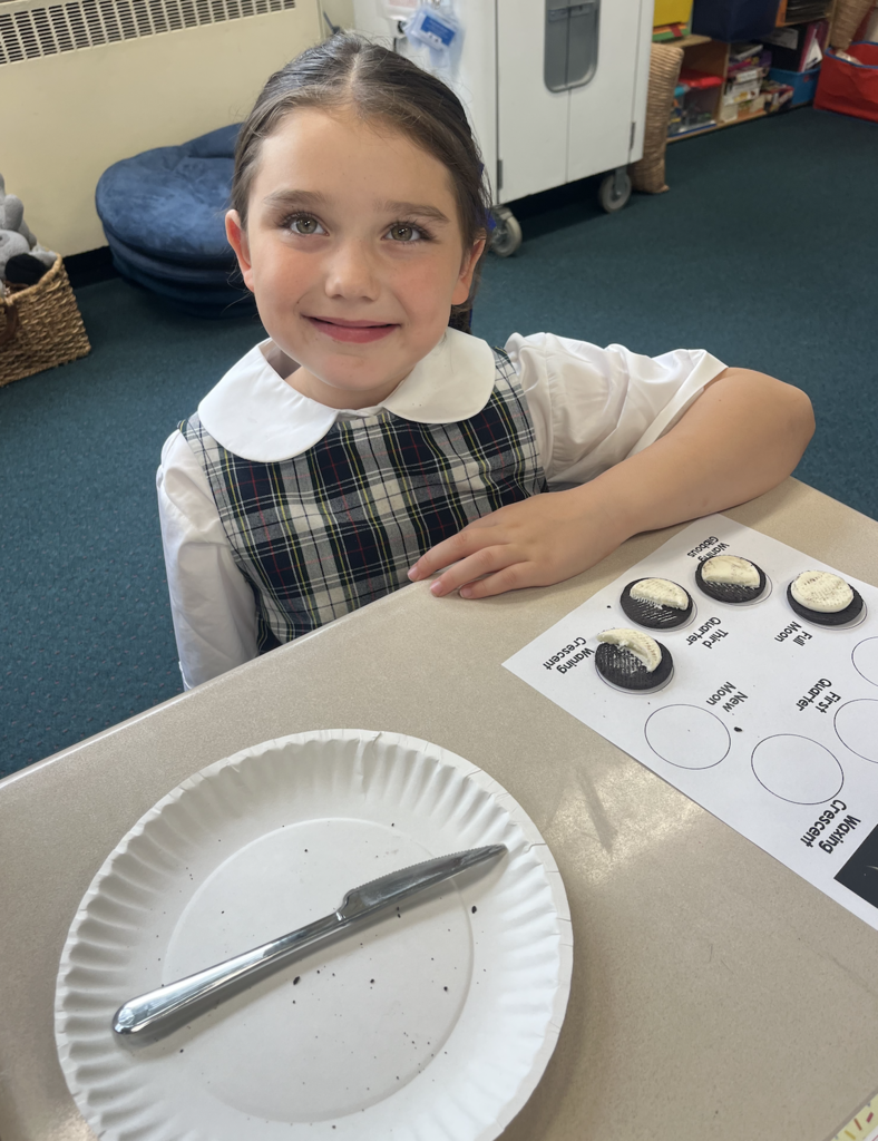 student with moon phases work sheet at desk and oreo cookies