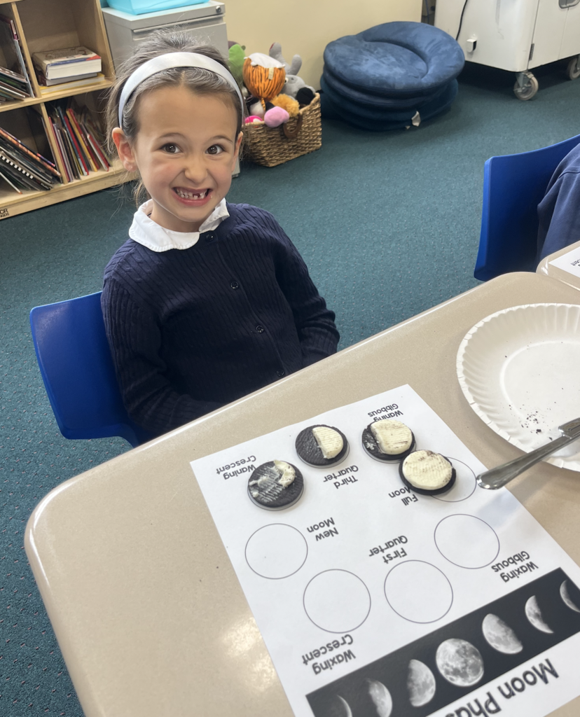 student with moon phases work sheet at desk and oreo cookies