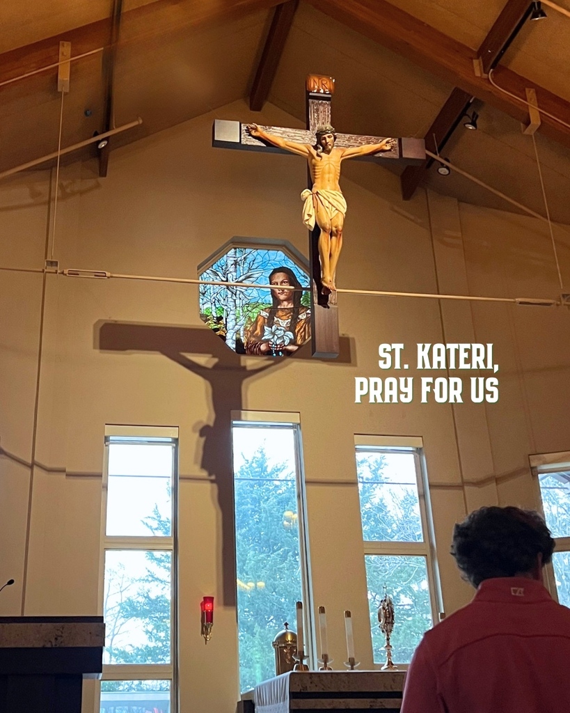 A boy prays in front of St. Kateri Chapel.