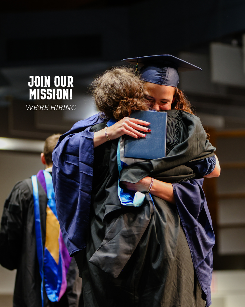 A graduate hugs a teacher.