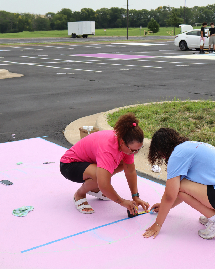 A girl and her mom paint their parking spot.