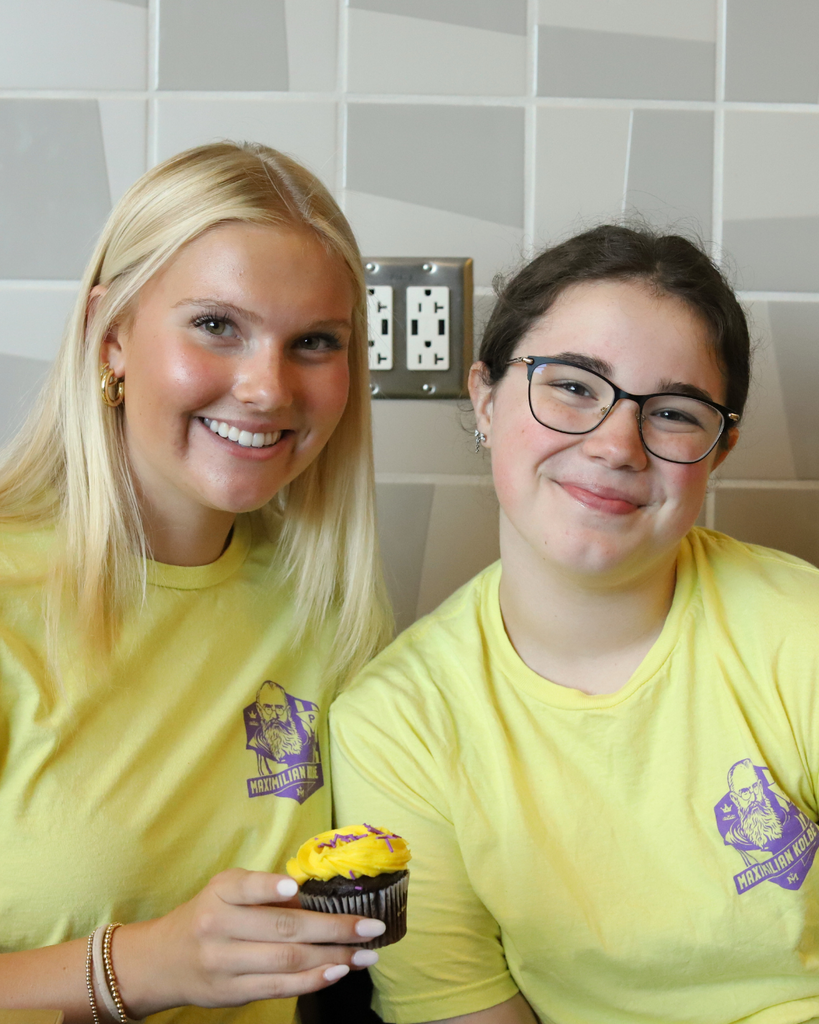 2 Kolbe girls pose with a cupcake.