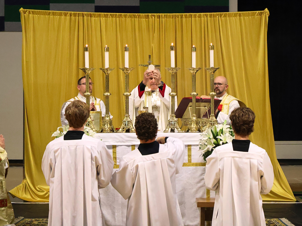 Bishop Johnston raises the Eucharist.