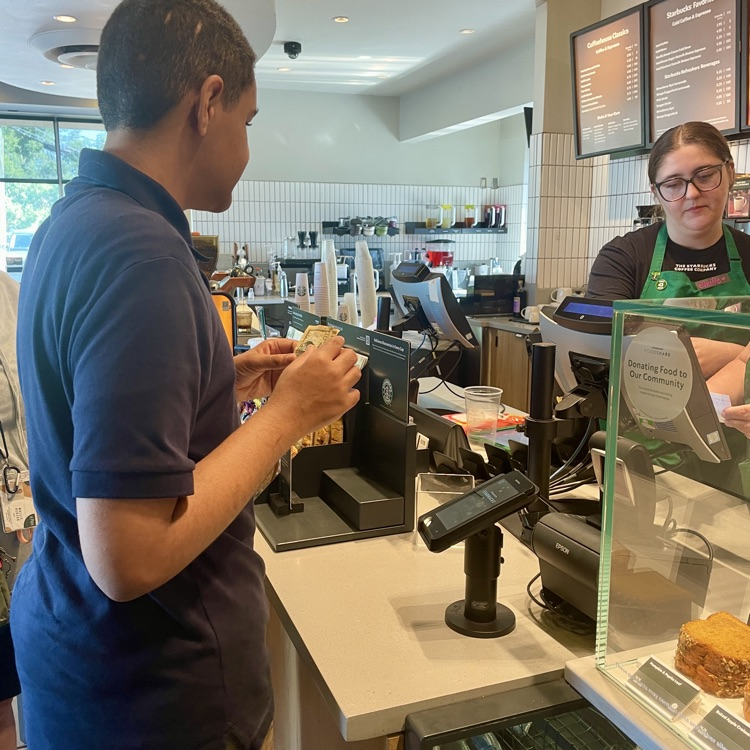 student paying for his Starbucks order