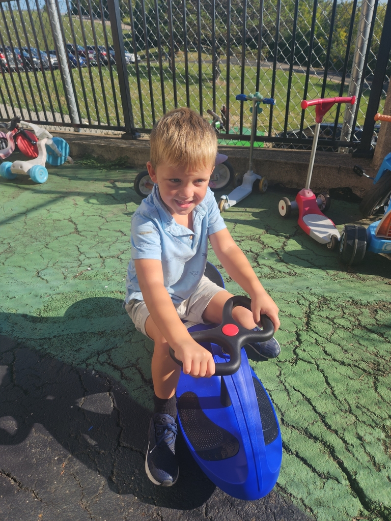 A student boy sitting on a blue scooter.