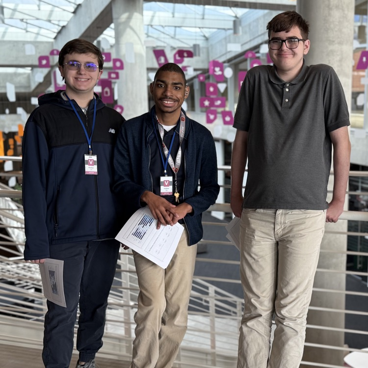 Three St. Rita School for the Deaf Work Study students stand together at 84.51° after presenting on Deaf Awareness, smiling in a bright, modern office setting.