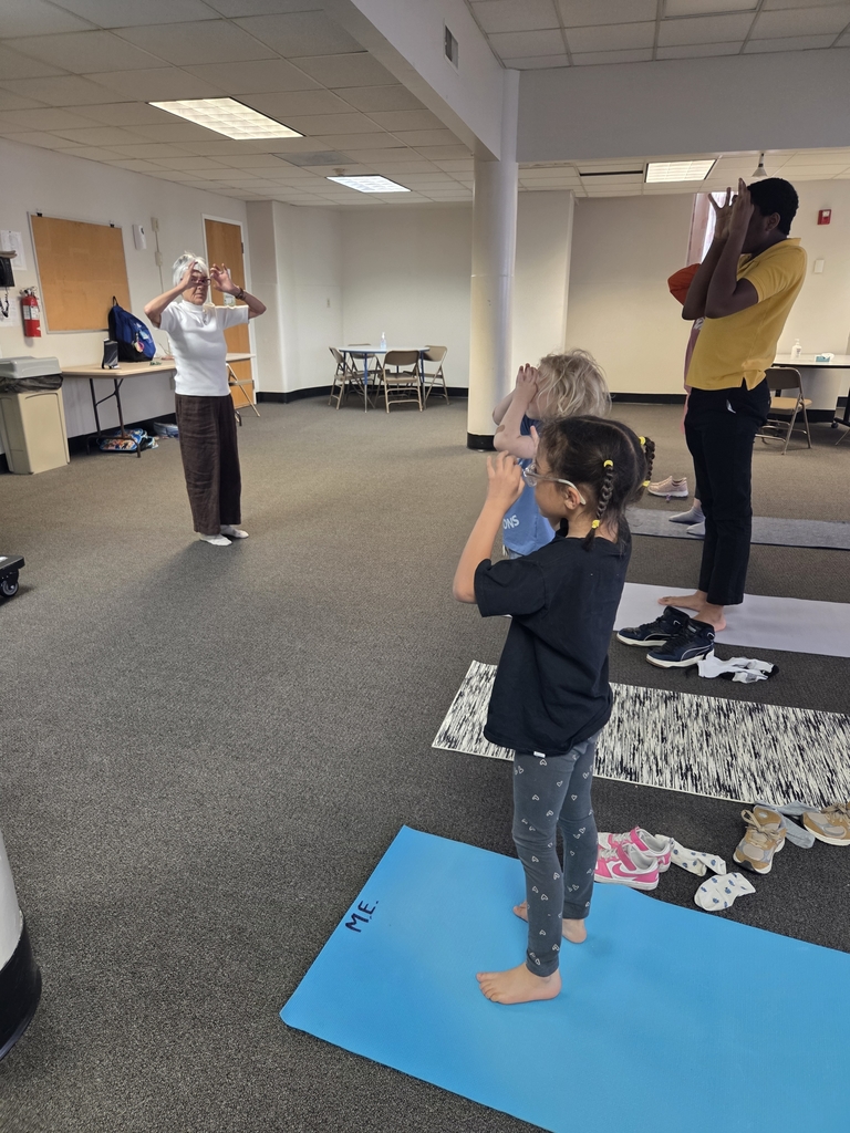 Four students and the teacher doing a standing yoga pose. 