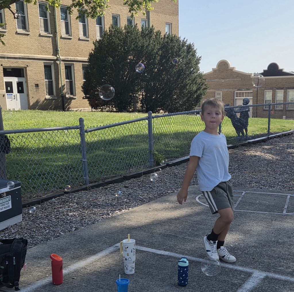 Picture: Student running through the bubbles on the concrete at the playground.