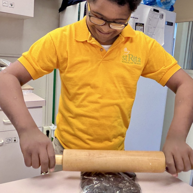 a student is crushing cookies to add to his pudding in home ec