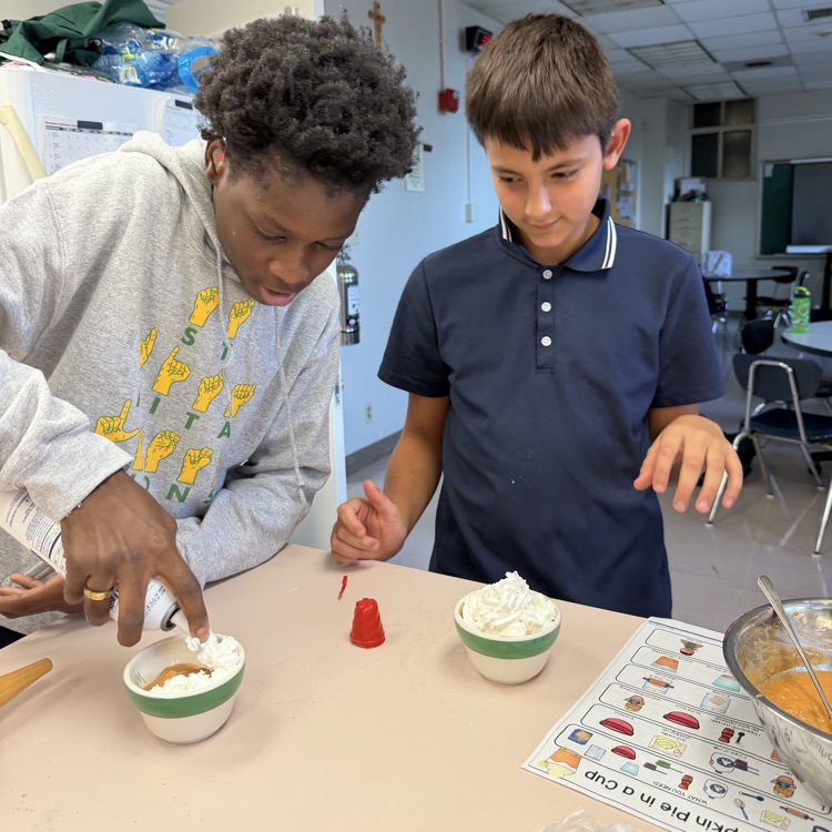 students are adding whip cream to their pumpkin pie in a cup!