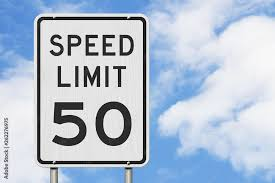 White rectangular traffic sign reading ‘Speed Limit 50’ against a blue sky.
