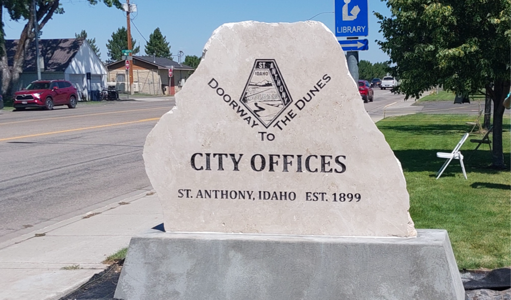 Stone monument identifying the City Offices in St. Anthony, Idaho, outside City Hall along a tree-lined street.