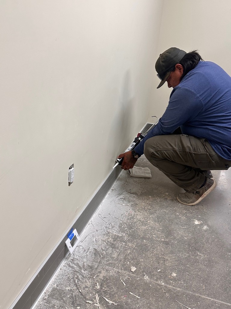 caulking edge of baseboards
