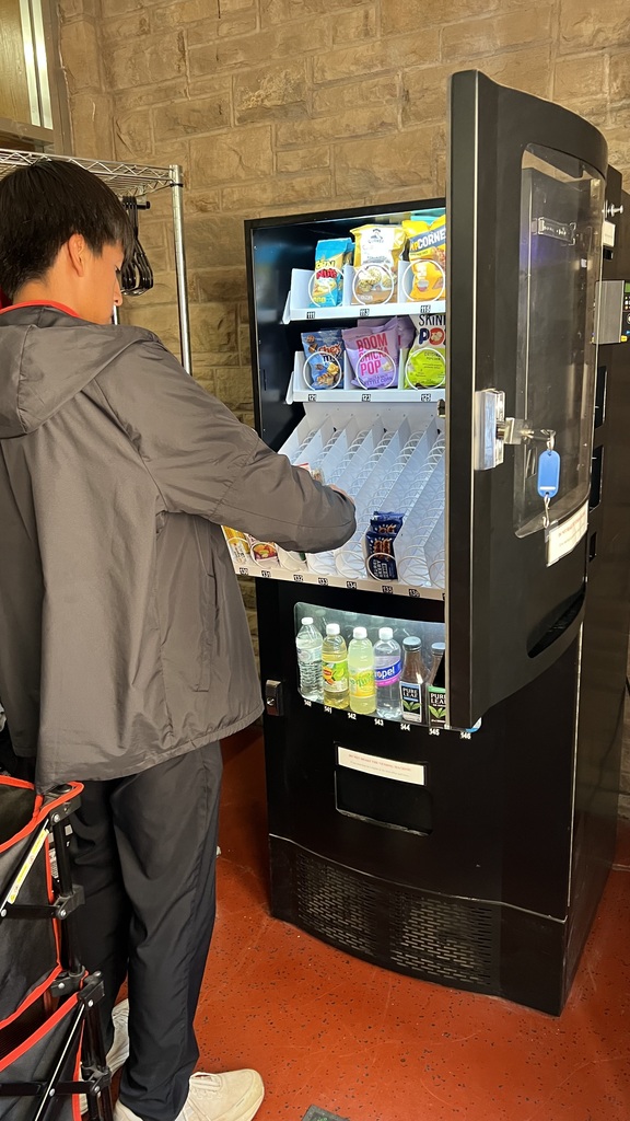 Cardinal Cafe Students learning how to Re stock vending machine