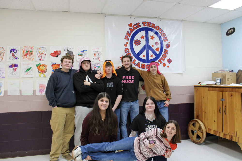 Small group of high school students and an adult smiling