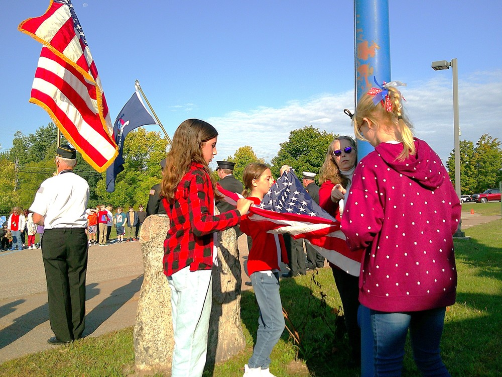 Photo of Girl Scout Service Unit #415 performing the flag raising ceremony, led by Pam Susice