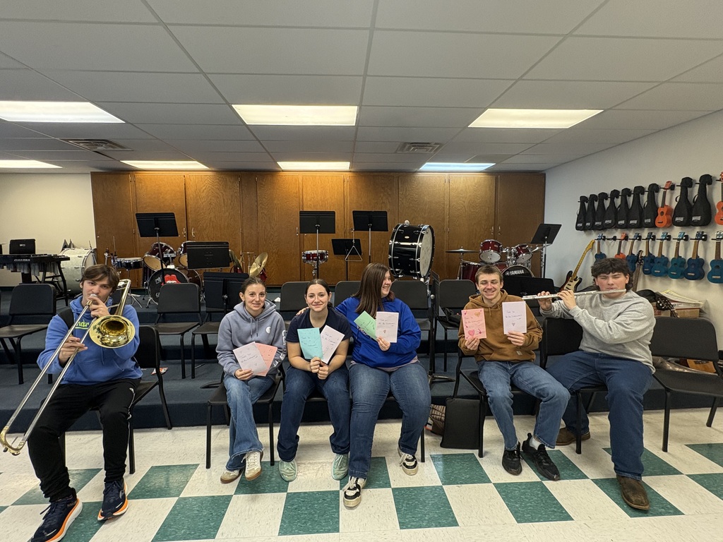 students holding instruments in a row smiling 