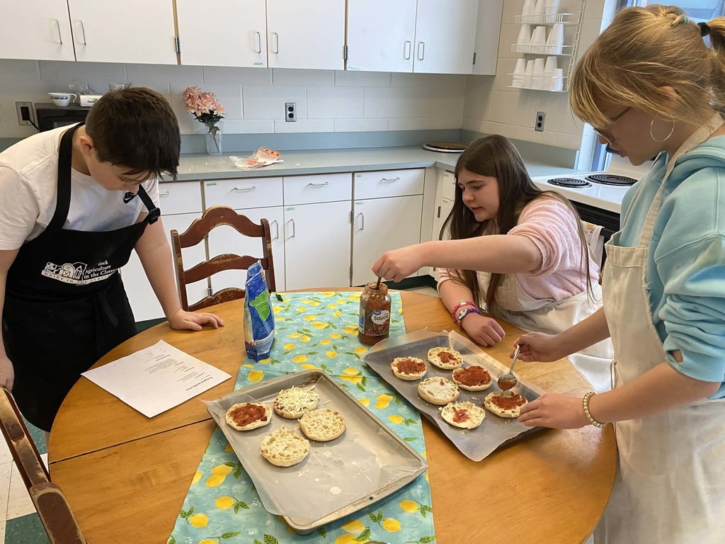 Kids creating pizza muffins 