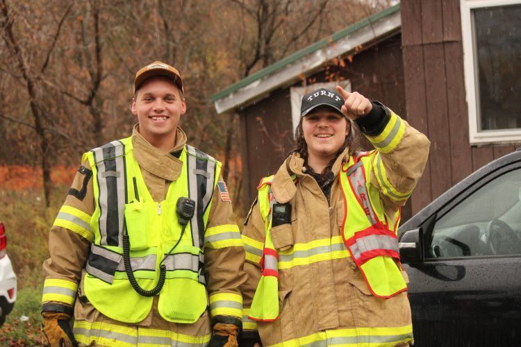 Two male high school students in their firefighting gear