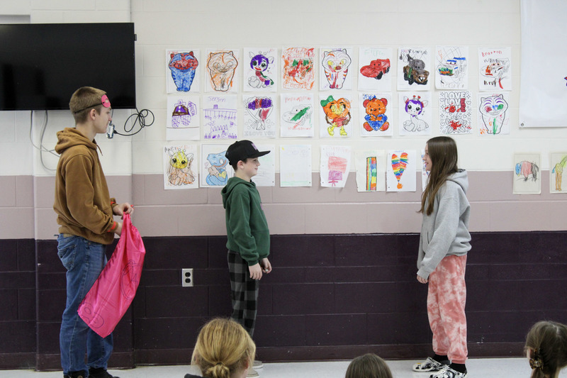 Male high school student working with a younger male and female student