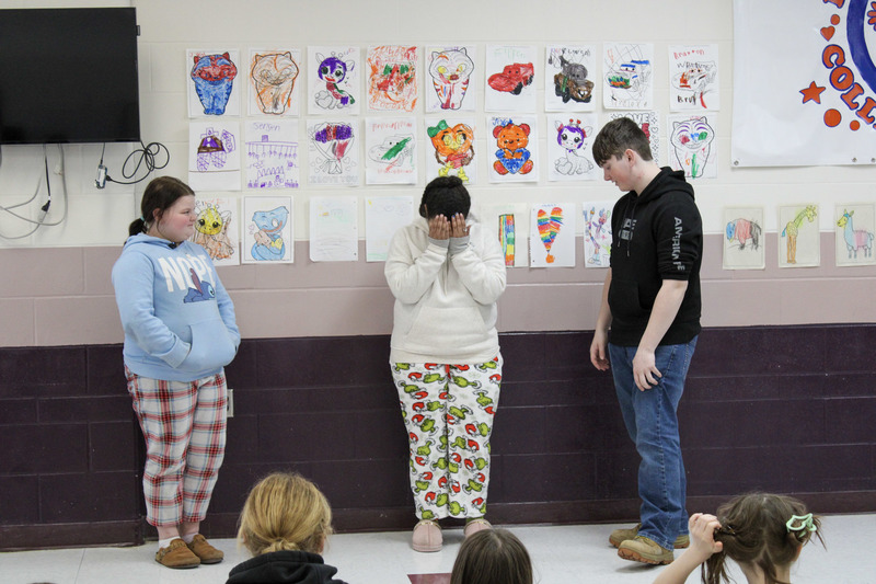 Male high school student working with two younger female students